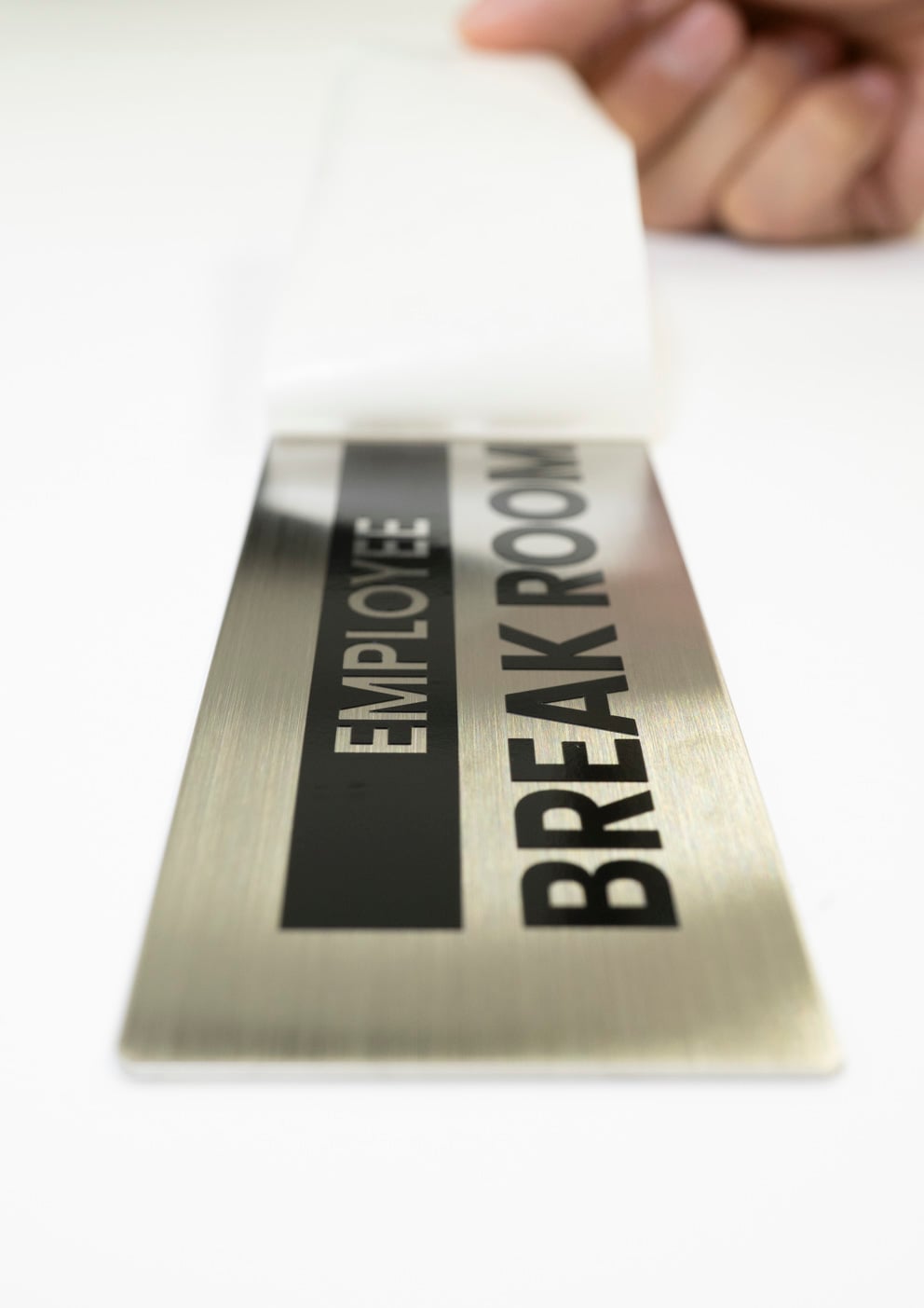 銘板にカッティングシートを貼っている写真